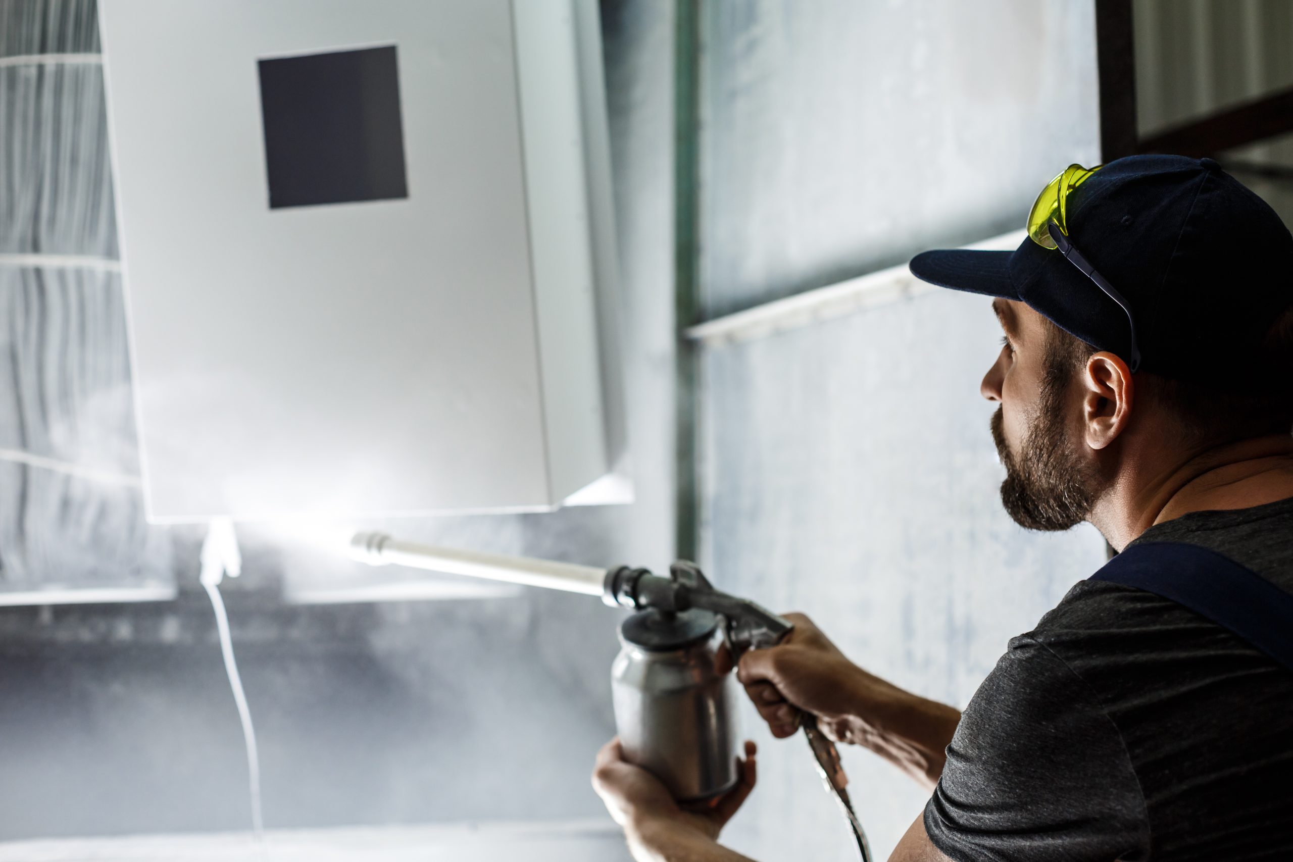 worker-painting-detail-with-air-spray-pistol-scaled military-grade powder coatings